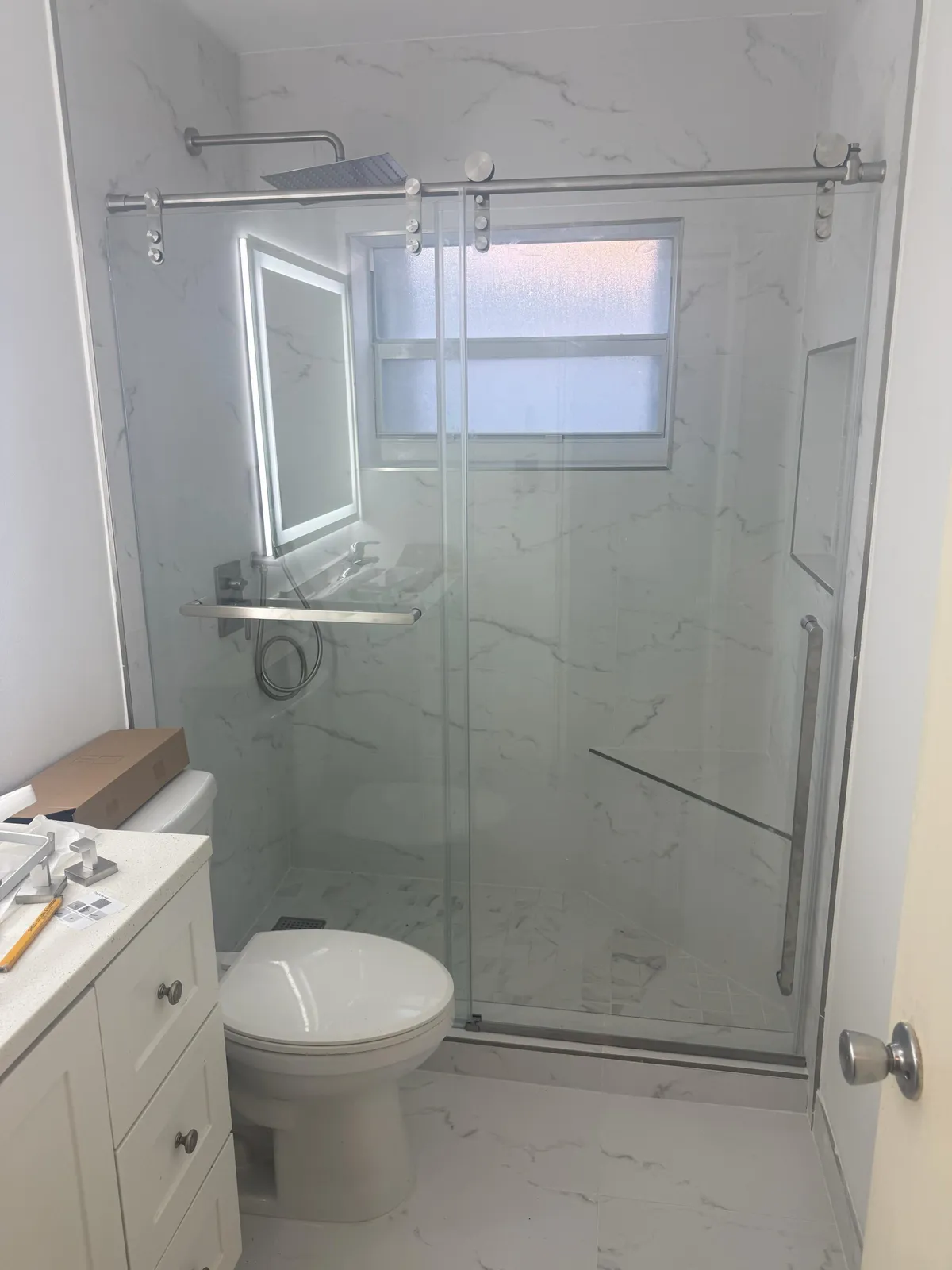 Remodeled bathroom with a glass walk-in shower, by MGS