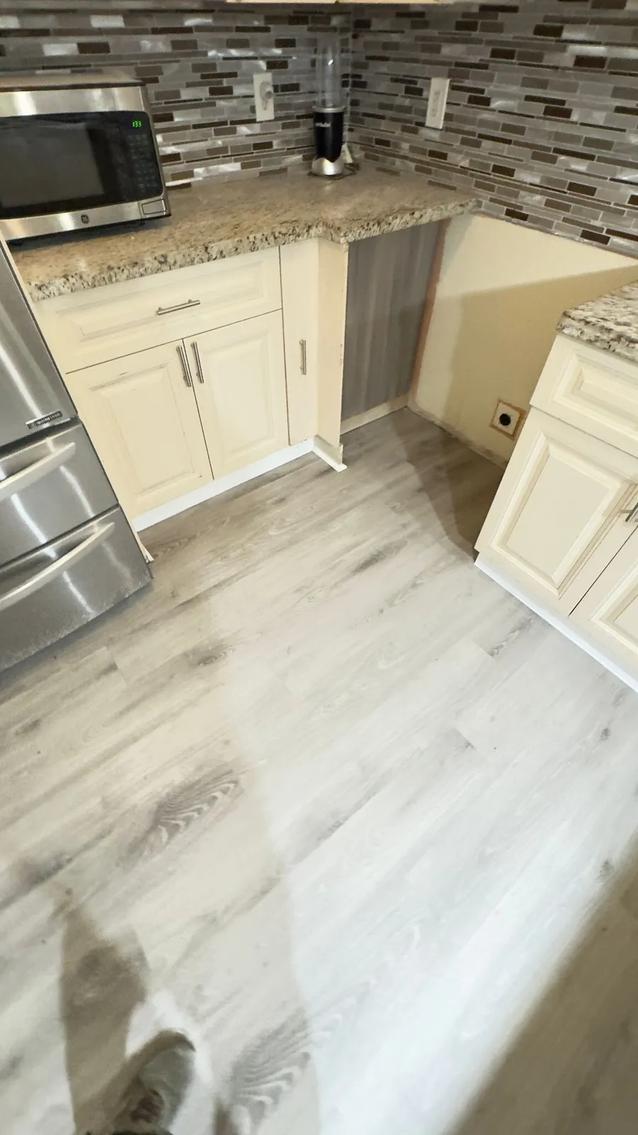 New plank flooring running through a kitchen in a Miami-Dade home, installed by MGS