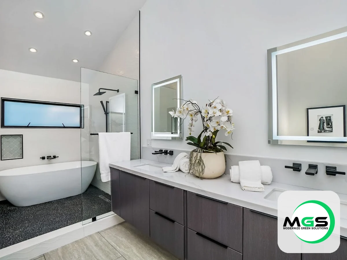 Bathroom remodel with a double vanity, freestanding tub, and backlit mirrors by Modernize Green Solutions