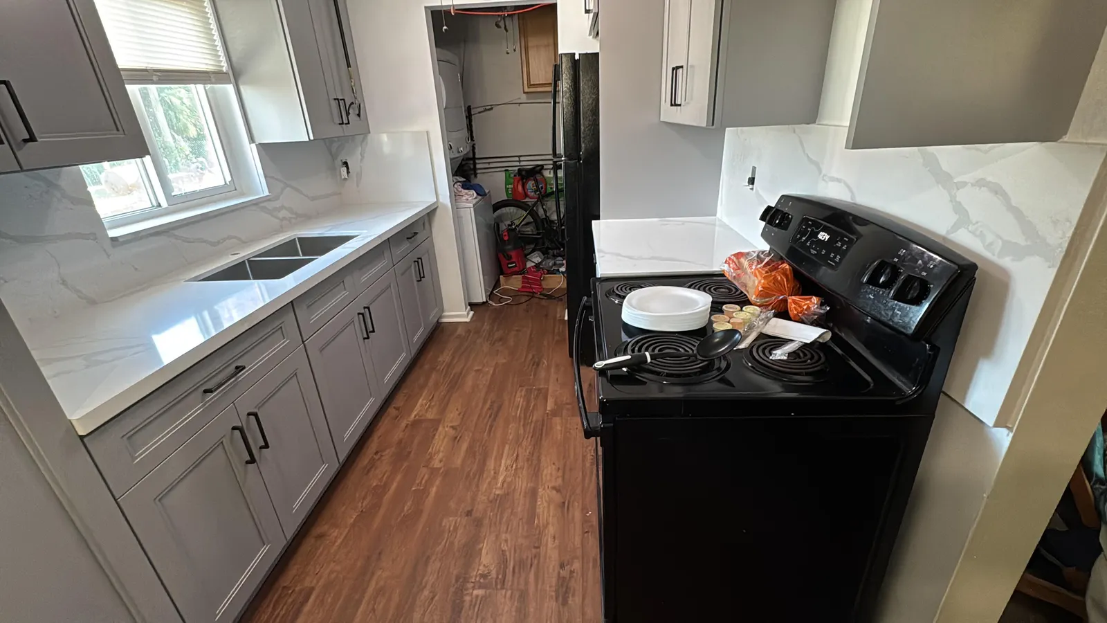 Remodeled kitchen with new cabinets, quartz counters and plank flooring by MGS